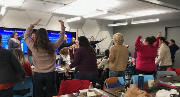 people standing stretching in conference room