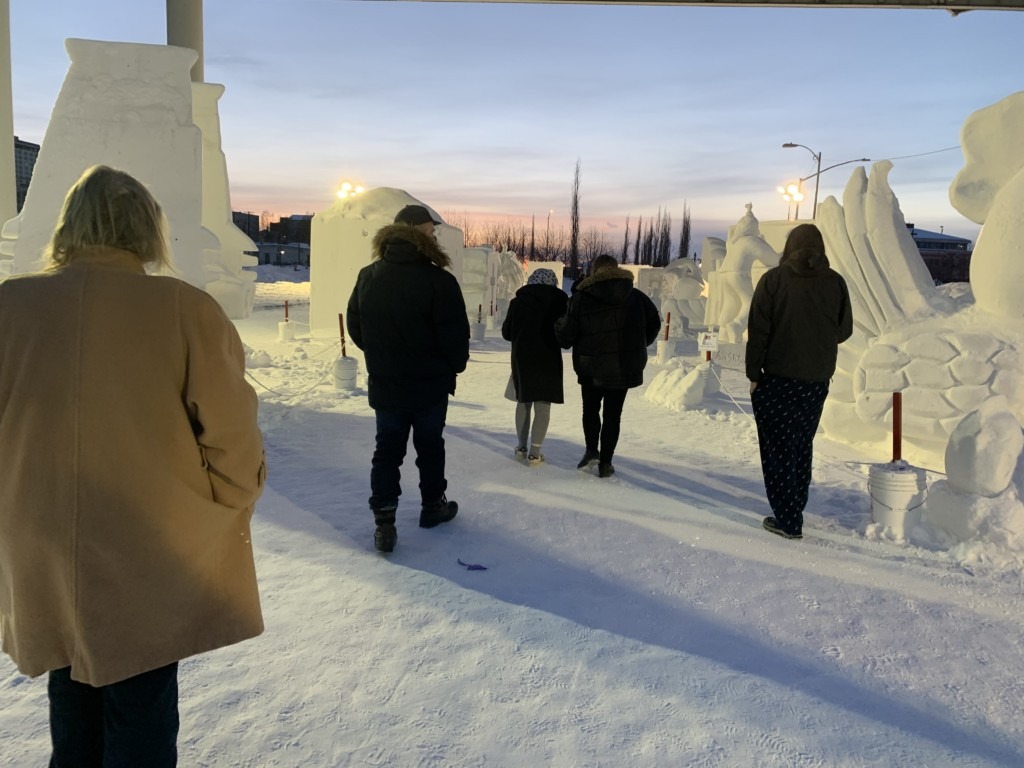 people walking among snow sculptures